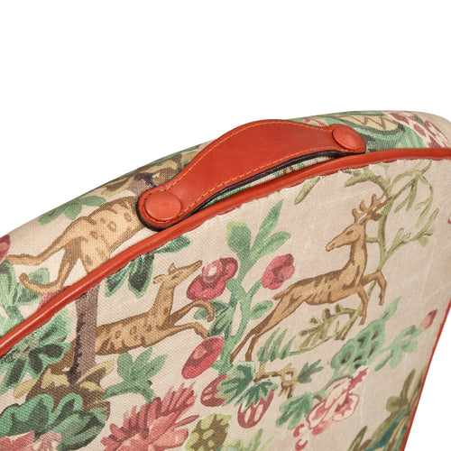 Floral and deer patterned bag with a red handle on a white background