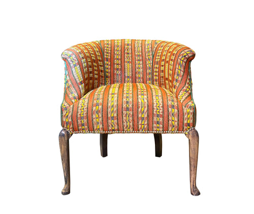 The hotline Mini Tub chair embraces you in it's curved arms, boasts a rollover top, and elegant wooden legs. Upholstered in Kit's new Hotline fabric with Christopher Farr, it takes on an new dynamic energy, with is textured stripe effect, and intricate woven stitch, in black, and yellow detailing , on earthy terracotta toned ground.