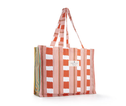 Our Bag for life is a large cotton bag, printed with Kit's Lost and found chequerboard print in orange and white, with green ticking detailing , combined with the variegated stripes of Peace and love, in orange, green, white and yellow, in the side gussets.