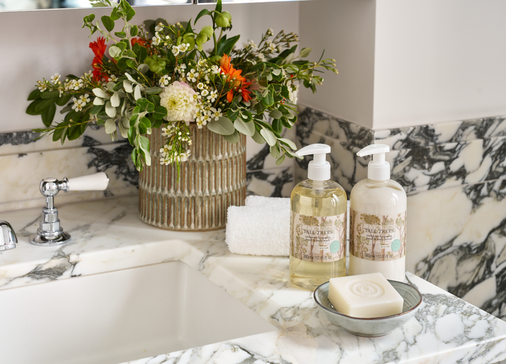 Tall Trees hand wash and lotion range shown displayed on a distressed pained side board.