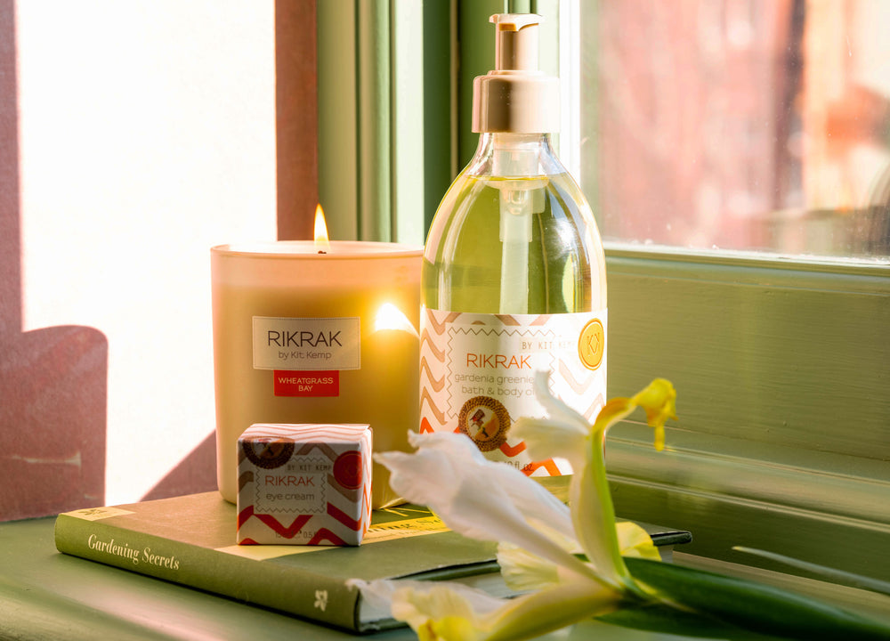 A round scented wheatgrass bay candle in a glass frosted vessel and a packaging box with green and blue ozone designs applied