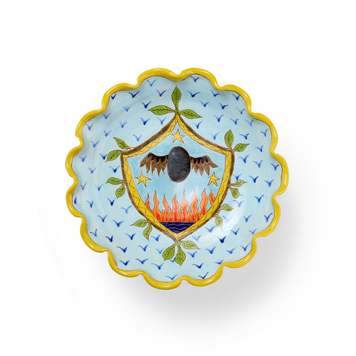 Decorative frilled edge dish with a central emblem featuring an flying egg and flames, surrounded by blue birds on a light blue background. 
