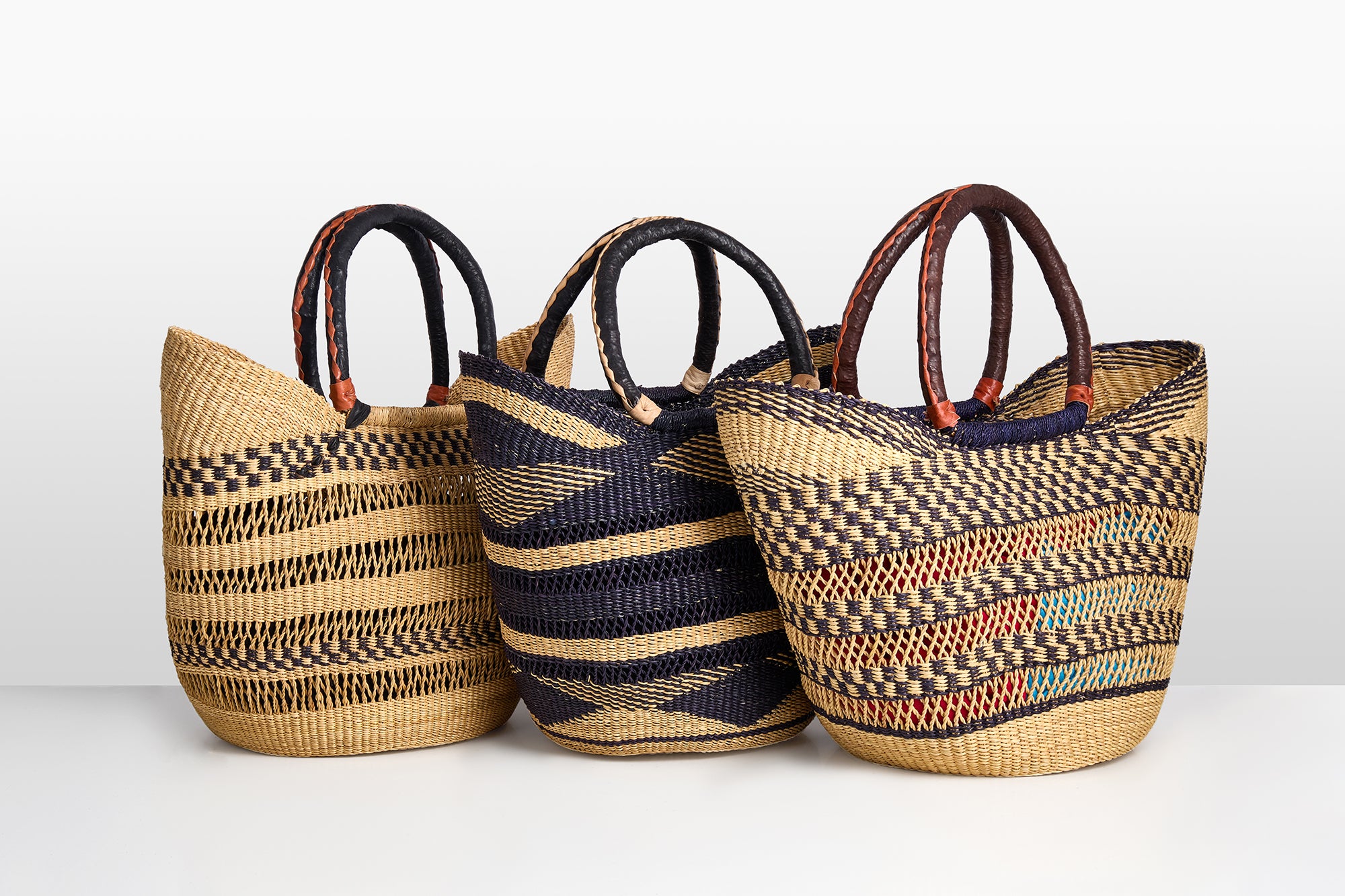 Three woven bags with striped patterns on a white background