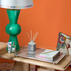 Green Bow Lamp paired with Diamond Lampshade in collaboration with Studio Zef, curated on Flintstone console, shown with Kit Kemp's room fragrances in Lavender and Eucalyptus, Monsoon design tray, and rich hand cream, for a luxurious home office style.