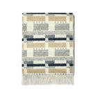 Kit Kemp for Christopher Farr Blue and Natural 100% Merino wool throw. Made in England, it showcases an intricate design with navy, gray, and beige colours, offering ultimate softness and warmth as a high-end luxury accessory.
