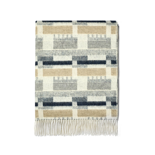 Kit Kemp for Christopher Farr Blue and Natural 100% Merino wool throw. Made in England, it showcases an intricate design with navy, gray, and beige colours, offering ultimate softness and warmth as a high-end luxury accessory.
