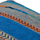 Sustainable Kit Kemp cushion in "Bunty" striped fabric, handcrafted in the UK using upcycled design studio materials. The heavy textured weave is accented by decorative orange embroidery and edged in coordinating piping. This eco-conscious statement piece brings a rich, artisanal mood to any interior space.