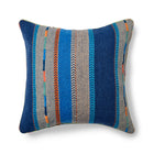 Kit Kemp Design Studio cushion featuring the "Bunty" fabric, a textured weave with wide vertical stripes in shades of blue and grey. The design is detailed with intricate embroidered chevrons in vibrant orange and turquoise. Reflecting a commitment to sustainability, this piece is made in-house using upcycled fabrics from previous studio projects and is finished with matching fabric piping.
