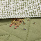 Close-up of the Buzz Off Quilted Bedspread in Green, showcasing intricate embroidered bee and floral motifs on quilted linen with exceptional craftsmanship by Kit Kemp for Chelsea Textiles.