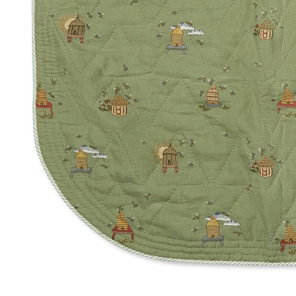 The Buzz Off Quilted Bedspread in Green, revealing the elegant quilted linen construction, embroidered pattern and softly rounded corners by Kit Kemp for Chelsea Textiles.