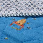 Close-up of the Buzz Off Quilted Bedspread in Blue, showcasing intricate embroidered bee and floral motifs on quilted linen with exceptional craftsmanship by Kit Kemp for Chelsea Textiles.