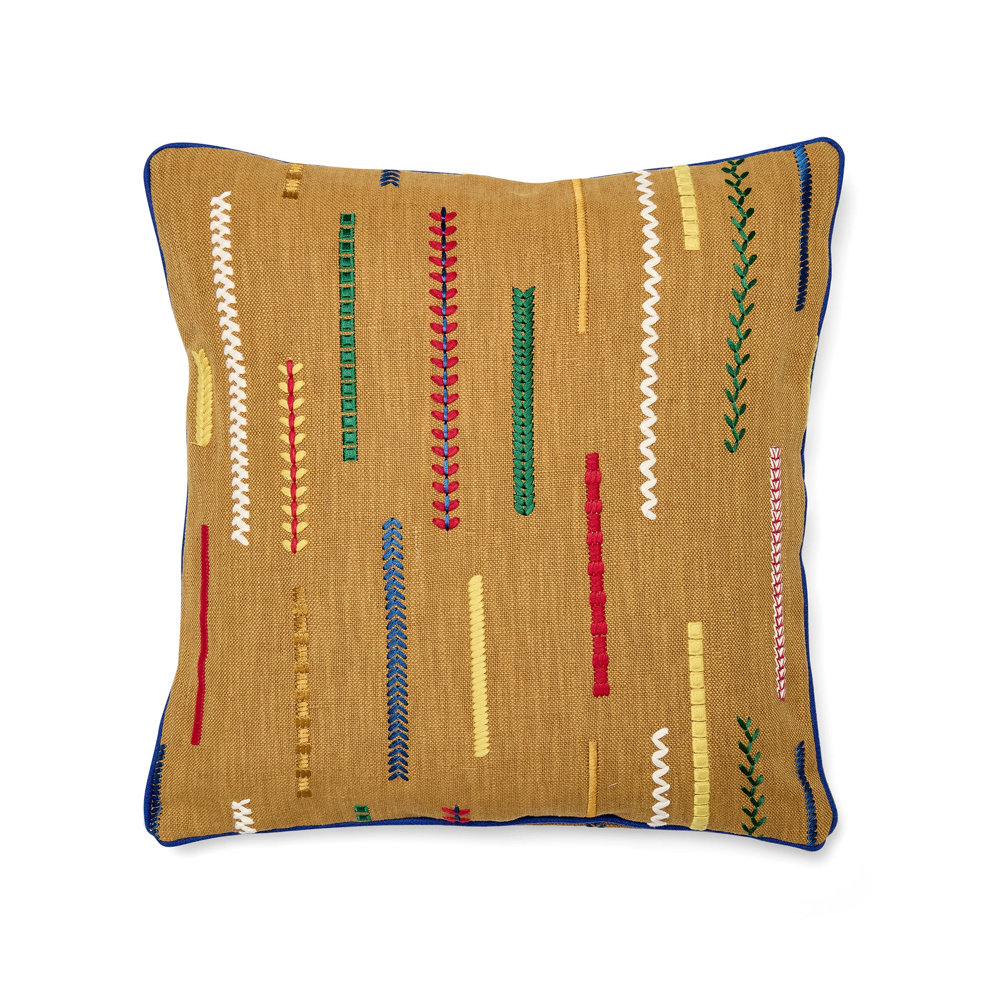 45cm x 45cm (18in x 18in) Kit Kemp Design Studio cushion in mustard yellow. The design features "Cayeres" fabric by Élitis, showcasing broken, multicoloured embroidered lines in shades of red, blue, and green on a rustic canvas. The cushion is finished with a sharp, contrasting cobalt blue piped edge.