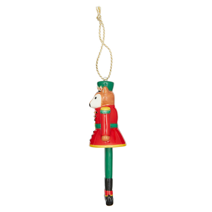 Christmas Bell Nutcracker fine china Ornament. Features a stylish fox head atop a brightly painted red and green uniform, complete with a gold crown and boots. The dangling design is a standout feature, making this a delightful and charming statement piece for your Christmas tree.