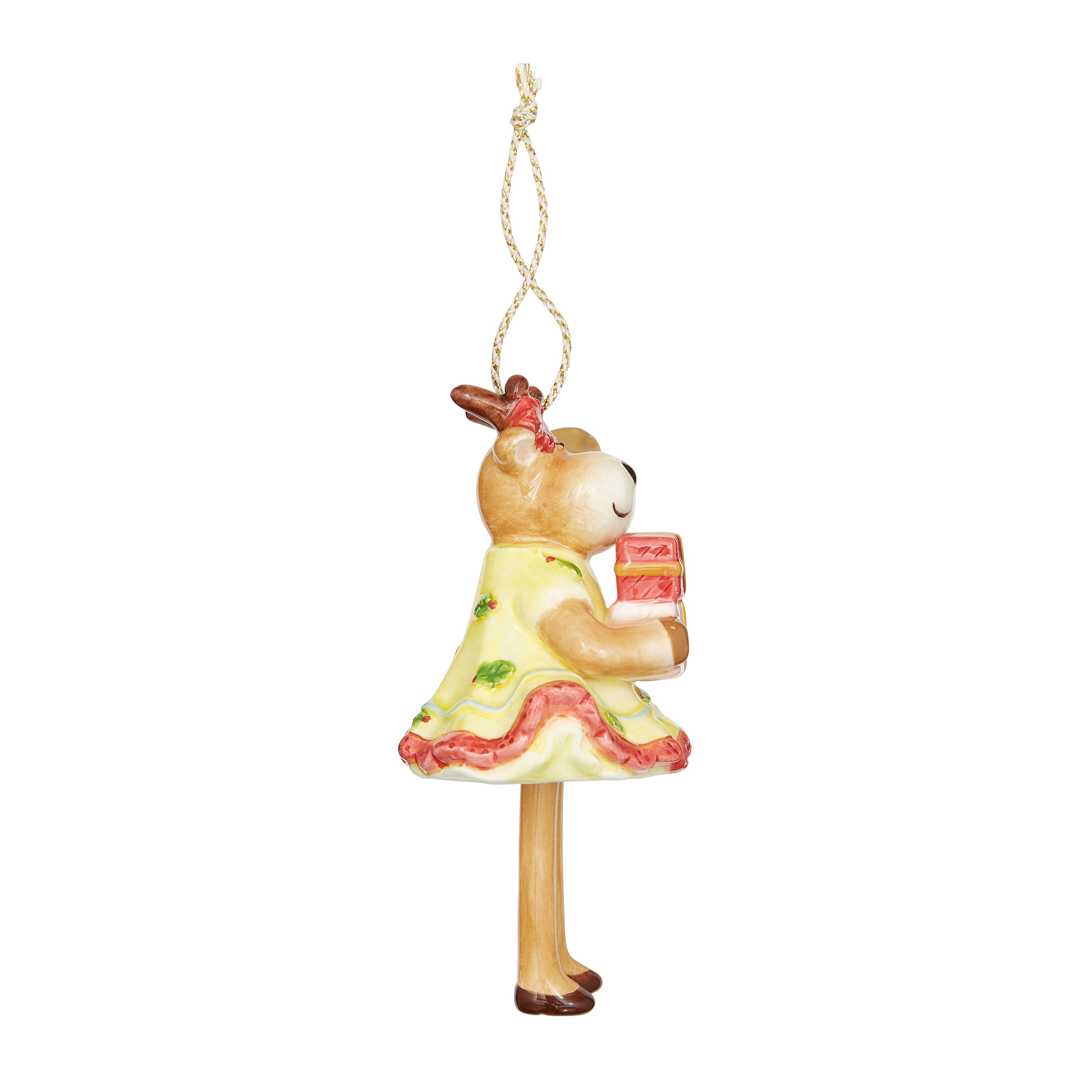 Festive fine china Christmas Bell Reindeer Ornament. Features a reindeer holding a bell and a present, dressed in a patterned yellow skirt, with a red bow. The signature dangling legs make this a unique and whimsical tree decoration and a delightful gift.