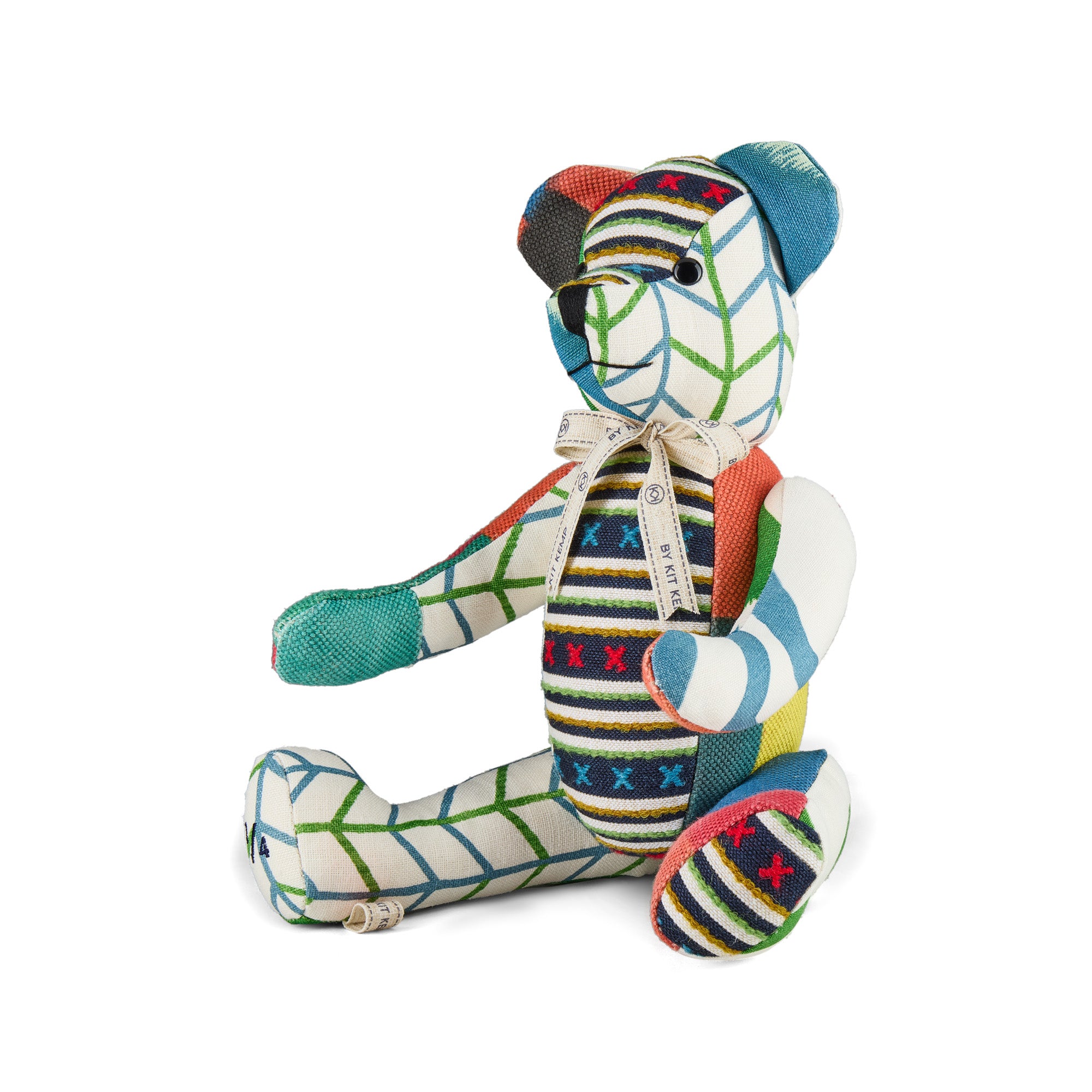 A one-of-a-kind Large Willow Bear from the Kit Kemp Patchwork Collection, handcrafted in the UK using repurposed fabric offcuts and recyclable filling. The bear showcases a mix of colourful geometric patterns in Kit Kemp's iconic fabrics with tones of pink, blue, green and navy.