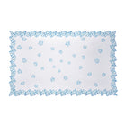 White cotton Kit Kemp tablecloth featuring a vibrant deep blue embroidered flower border with intricate cutwork edging. This handmade in India piece measures 140cm by 240cm (approximately 55in by 94in. The understated elegance makes it perfect for both special occasions and daily dining, especially when paired with Petal Cutout napkins and Sailor's Farewell tableware.