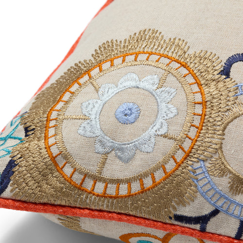Close-up of a Kit Kemp Design Studio cushion showing intricate crewel-work embroidery in gold, orange, and cornflower blue. Hand-finished in the UK using upcycled fabric remnants from studio projects, this 50x50cm (20x20") piece highlights artisanal texture and vibrant tonal piping.
