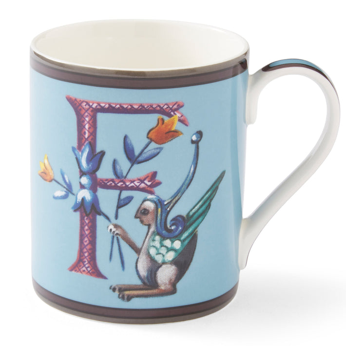 The purple cross hatched f on this pale blue mug forms a decorative background to the mythical winged creature, with its blue and yellow corn-like floral posy.