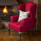 Essential comfort cushion in Kit Kemp playful design on striking pink Wing Chair, ideal setting by a cosy fire or in a favourite room. 