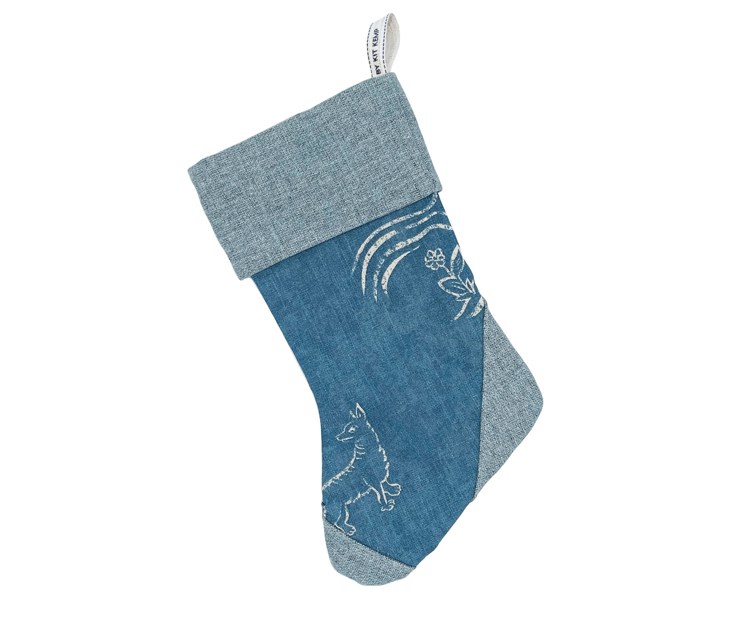 Contemporary Christmas stocking crafted from a blue textured fabric, adorned with a beautiful white Friendly Folk fox illustration. Perfect for thoughtful festive gifts and adding an unexpectedly fresh touch to seasonal home styling.