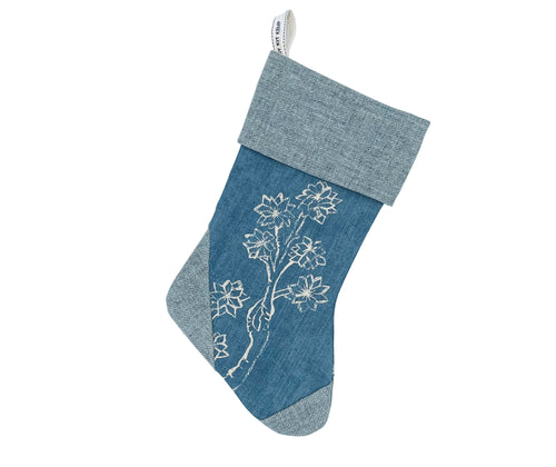 Contemporary Christmas stocking crafted from a blue textured fabric, adorned with a beautiful white Friendly Folk illustration. Perfect for thoughtful festive gifts and adding an unexpectedly fresh touch to seasonal home styling.