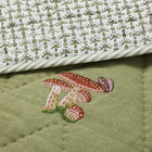 Close-up of the Good Trip Quilted Bedspread in Green, showcasing intricate embroidered mushroom and woodland motifs on quilted linen with beautifully crafted detailing by Kit Kemp for Chelsea Textiles.