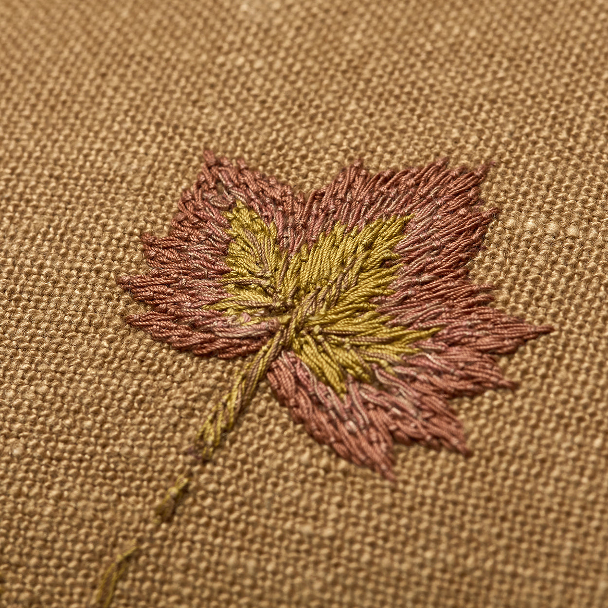 Close up of Good Trip yellow cushion with hand embroidered leaf detail. Exclusively at Shop Kit Kemp.