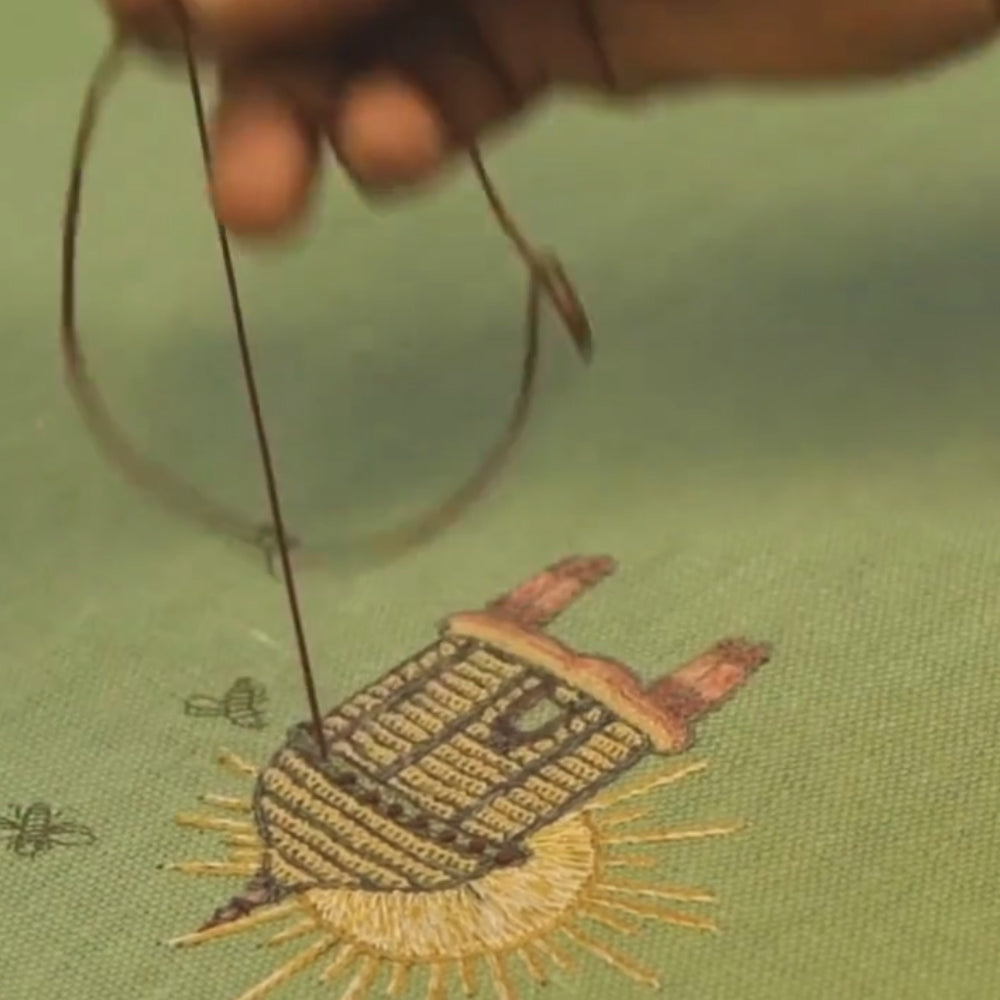 A detail of a stitcher hand stitching a weekend collection bedspread 