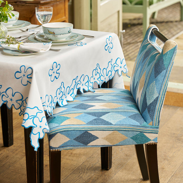 A Kit Kemp handle chair at a table dressed with Petal cutwork tablecloth and sailors farewell fine bone china 
