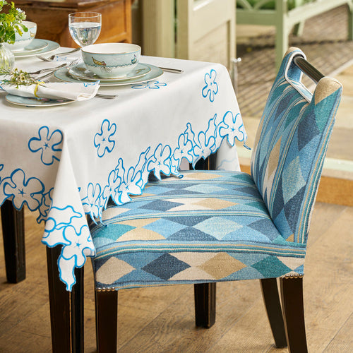 A Kit Kemp handle chair at a table dressed with Petal cutwork tablecloth and sailors farewell fine bone china 