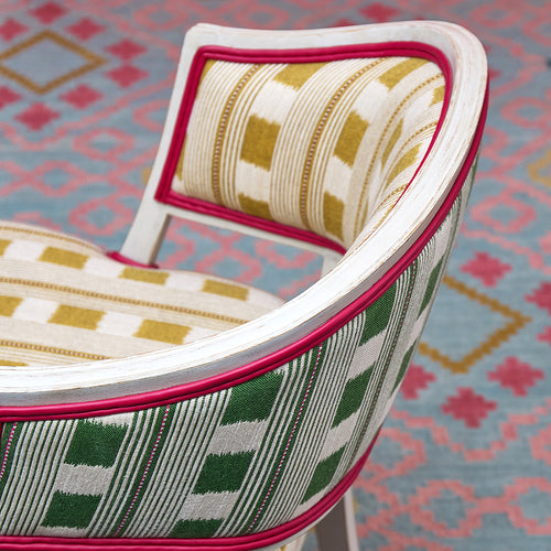 Whitby chair and jelly roll rug with geometric pattern designs, handwoven by skilled artisans using wool and cotton into a statement piece that offers striking colour combinations and a warm and welcoming style. 