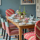 Susan Chairs in Busy Lizzie fabric bookend the Sailor's Farewell tableware display, with Handle chairs on either side to complete the dining setting. 