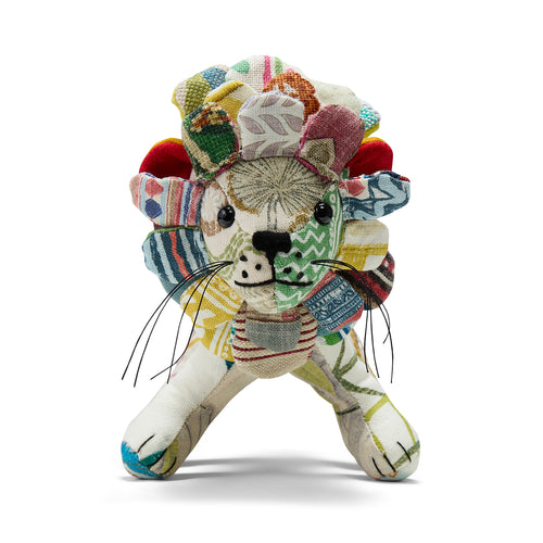 A front view of Lennart the Lion, a handmade soft toy from the Kit Kemp Patchwork Collection. This one-of-a-kind design features a face crafted from vibrant, striped upcycled fabric offcuts and a mane composed of individual fabric petals.