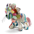 A side profile of Lennart the Lion highlighting the sustainable craftsmanship of the Kit Kemp Design Studio. The body is made from various patterned fabric offcuts, including Heart of Oak, floral and striped prints, and features a pink yarn tail.