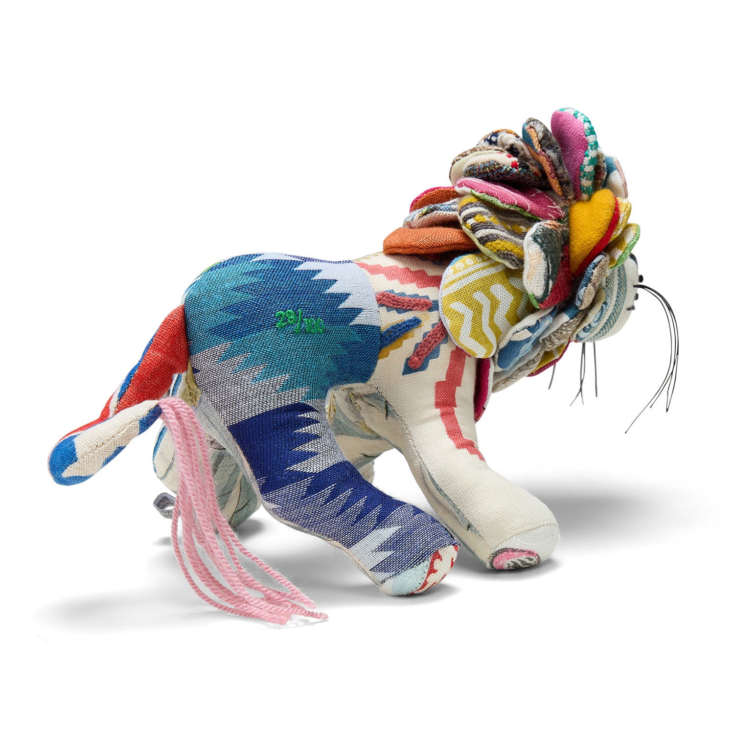 A three-quarter view of Lennart the Lion, displaying the eclectic mix of Busy Lizzie blue, green, and cream patterned fabrics. This sustainable design breathes new life into Design Studio offcuts through meticulous UK-based hand-stitching.