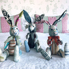 A trio of collectible Minnie Rabbits, each with its own unique personality stitched into every detail. These high-end patchwork animals represent sustainable luxury, featuring a rich palette of jewel tones and neutral textures that reflect the sophisticated British design heritage of Kit Kemp.