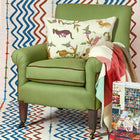 Mythical creatures cushion paired with green Leo sofa and Checkerberry throw, perfect for layering home comforts and touches of Kit Kemp magic.