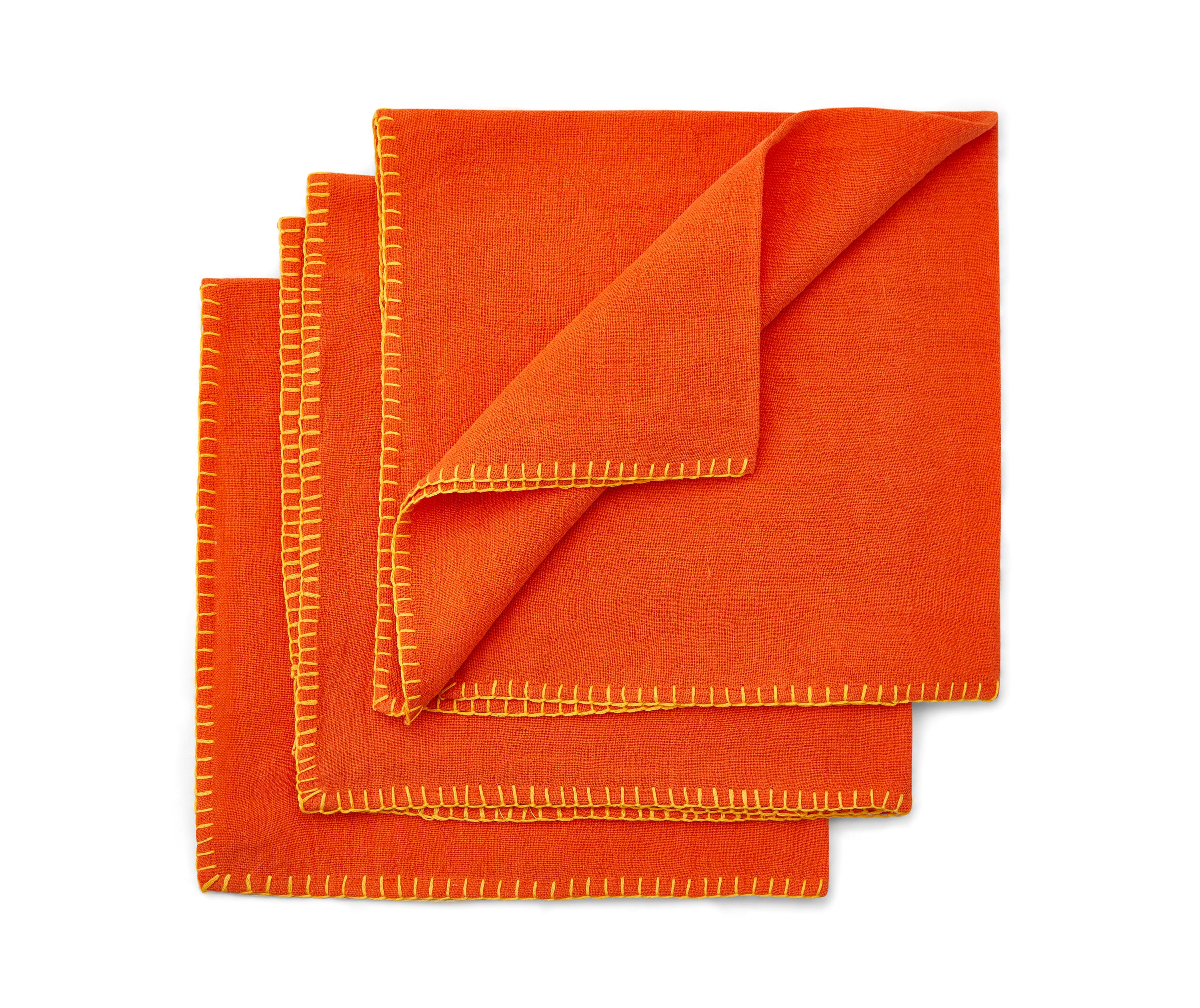 Three blanket stitch napkins fanned out in orange