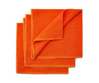 Three blanket stitch napkins fanned out in orange