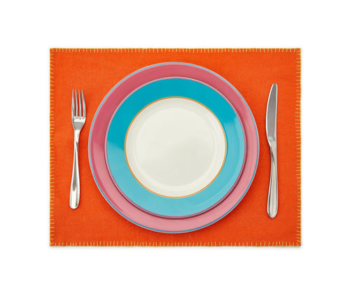 Orange placemat with yellow blanket stitch with pink and turquoise plates and fork and knife