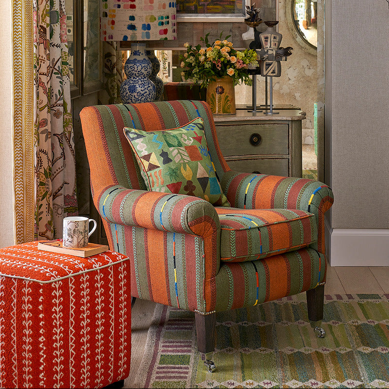 Potato print cushion in green, paired with Leo chair in Bunty fabric, designed by Kit Kemp. Little Weed cube stool in foreground with Tall Trees mug.