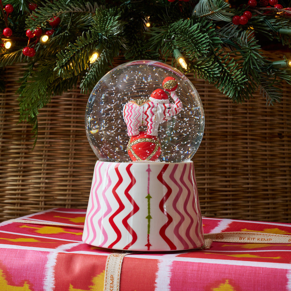 The Rick Rack Snow globe, which combines one of Kit Kemp's signature fabric designs, in bright pinks and red zig zag stripes with Jambo, our patchwork elephant to make this Christmas collectable.