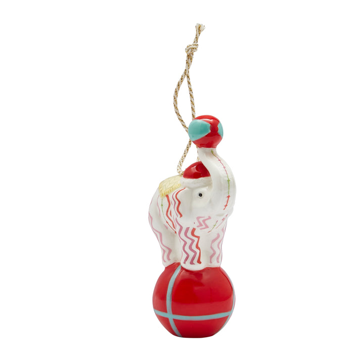 A unique Circus Elephant Ornament in fine china, part of the coveted Kit Kemp for Spode collection. The elephant, decorated with the modern pink and red Rick Rack pattern, balances skilfully on a bold red ball. This playful, artistic decoration is a true conversation starter and an ideal luxury gift for the holidays.