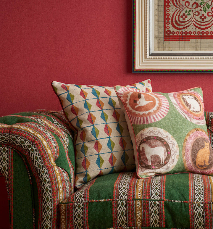 Green tones and red accents cushions and sofa fabrics in a Kit Kemp interior collection exclusive to Shop Kit Kemp.