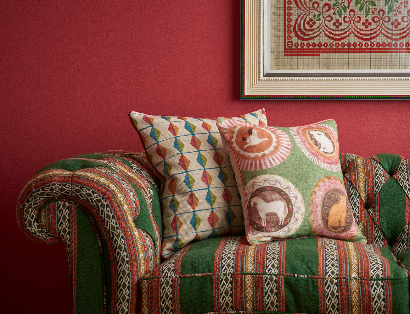 Green tones and red accents cushions and sofa fabrics in a Kit Kemp interior collection exclusive to Shop Kit Kemp.