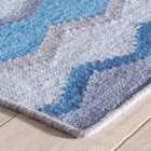Close up on Safety Net Blue rug in 79% Wool/15% Cotton/4% Rayon/2% Polyester composition, handcrafted in India.