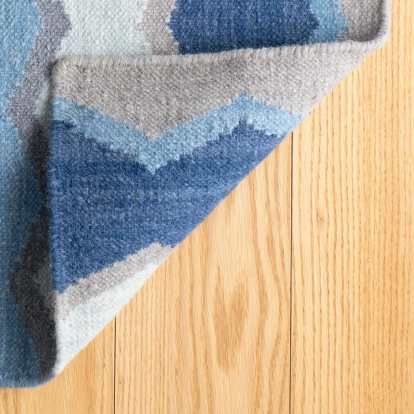 Backing detail on the Safety Net blue rug, with perfect finish on this handcrafted large flooring piece, ideal for living rooms, hallways and high traffic interior spaces.