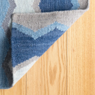 Backing detail on the Safety Net blue rug, with perfect finish on this handcrafted large flooring piece, ideal for living rooms, hallways and high traffic interior spaces.