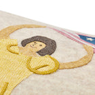 Close-up of the artisan-made appliqué, showing the lady in a yellow dress waving American flag, hand-stitched on soft 100% Chamonix wool.