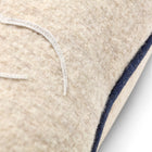 Edge profile of the square wool cushion highlighting the navy blue piped edge and the texture of the British made wool.